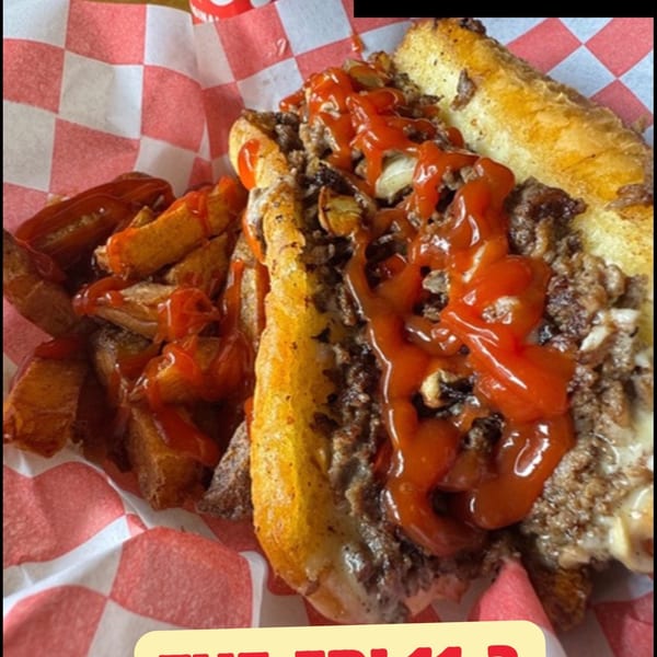 Apollo's Steaks cheesesteak with fries and ketchup, next to a Coca-Cola can.